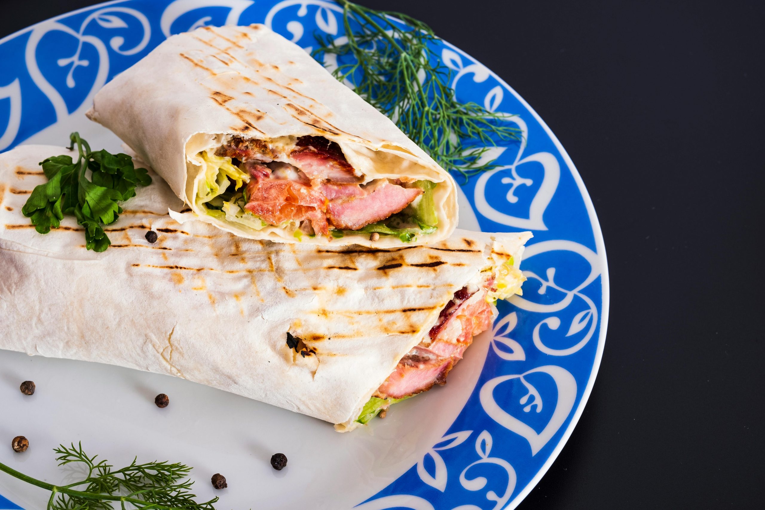 Delicious grilled chicken wrap with fresh vegetables served on a colorful plate.